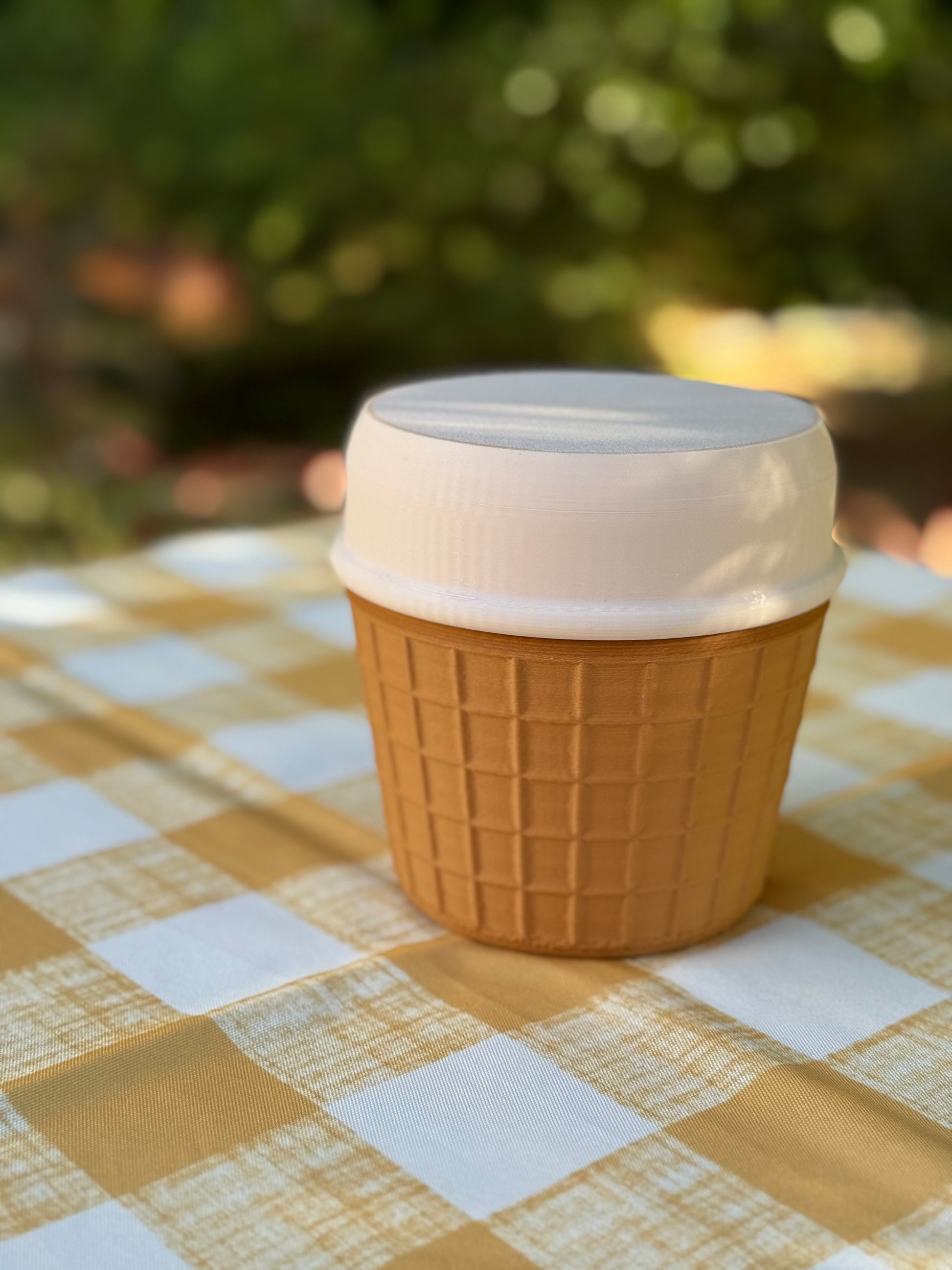 Portable Ice Cream Cooler with white lid on a checkered tablecloth, outdoors, ice cream portable cooler, ice cream pint cooler